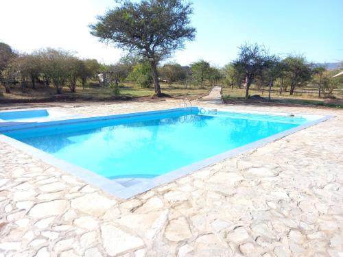 a swimming pool in the middle of a stone yard at ELANGATA OLERAI LUXURY TENTED CAMP in Narok