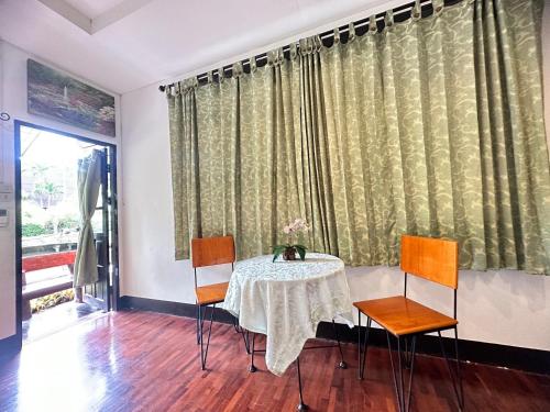 Soft Resort Kad Farang Hangdong في Ban Yang Plao: غرفة طعام مع طاولة وكراسي