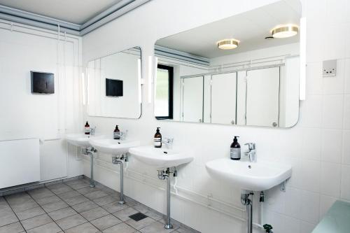 a bathroom with three sinks and two mirrors at Jägerhuset in Maribo