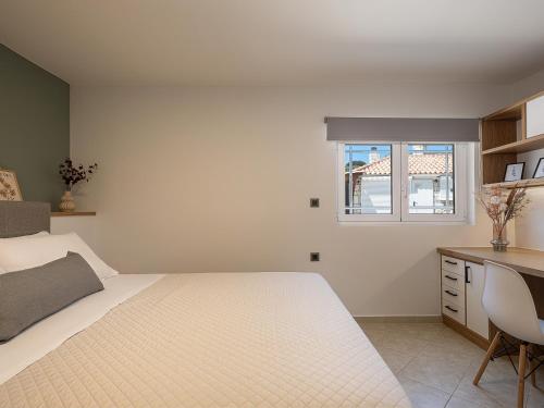 a bedroom with a bed and a desk and a window at Elysian Sea-View Chania in Stérnai