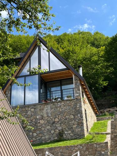 una casa con una finestra su un muro di pietra di Columbus Villas a Vermosh