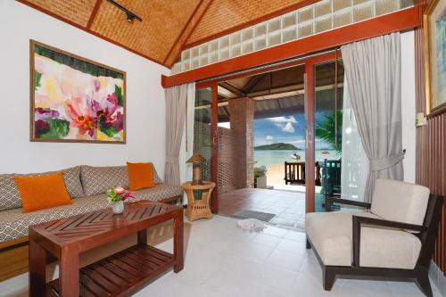 a living room with a couch and a table at Friendship Beach Resort & Atmanjai Wellness Centre in Rawai Beach