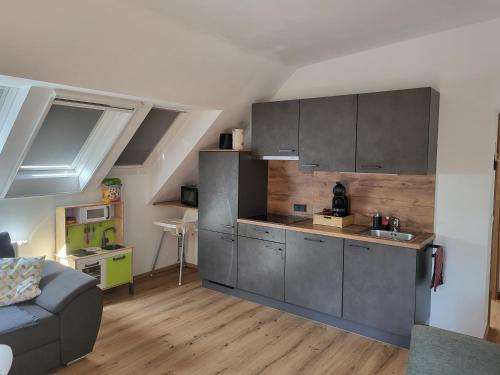 - une cuisine avec des placards gris et un canapé dans la chambre dans l'établissement Apartments Brunnmeisterhof, à Salzbourg