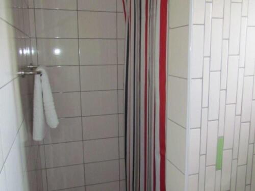 y baño con ducha con cortina de ducha roja. en Eland Safari Hotel Nyeri en Nyeri