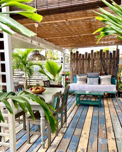 a patio with a table and chairs and a bed at La Cabane du Pecheur in Rivière Noire