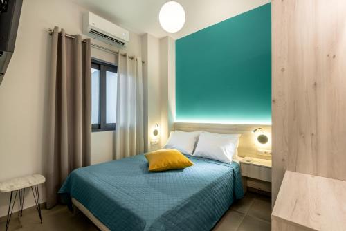a bedroom with a bed with a blue wall at Ifigenia's Seaside Casa in Agia Marina Nea Kydonias