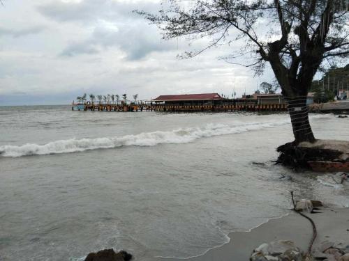 a beach with a pier in the water at Sea Inn Guesthouse Sihanoukville in Sihanoukville