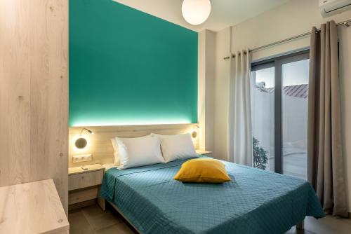 a bedroom with a bed with a blue wall at Ifigenia's Seaside Casa in Agia Marina Nea Kydonias