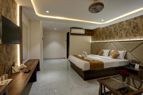 a hotel room with a bed and a television at Ramya Residency Navi Mumbai in Navi Mumbai