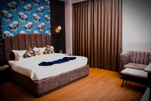 Pokój hotelowy z łóżkiem i krzesłem w obiekcie Hotel Azul Ganga w mieście Rishikesh