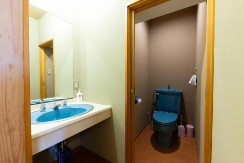 a bathroom with a blue toilet and a sink at -izen 高田- 柳精庵 in Joetsu