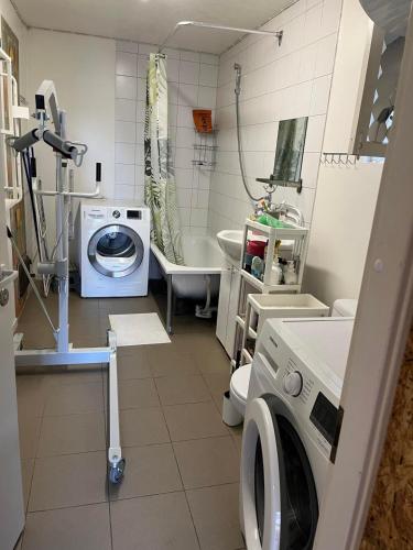 ein Badezimmer mit einer Waschmaschine und einem Waschbecken in der Unterkunft Kodune Apartment Võru vanalinnas in Võru
