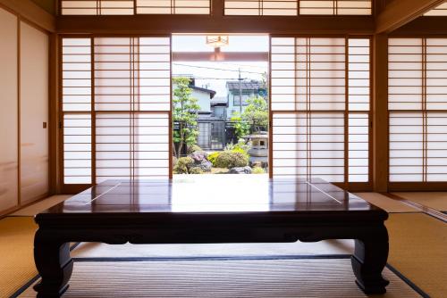 a room with a table in front of a window at -izen 高田- 柳精庵 in Joetsu