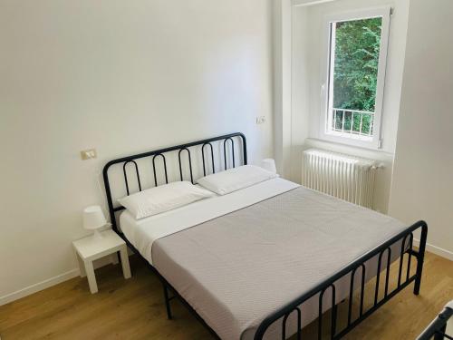 - une chambre avec un grand lit dans une pièce dotée d'une fenêtre dans l'établissement Novecento Luxury Residence 4 Stelle, à Montese