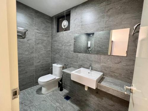 ein Badezimmer mit einem weißen WC und einem Waschbecken in der Unterkunft Carmen Leisure Homestay - Woodsbury Suites Butterworth in Butterworth
