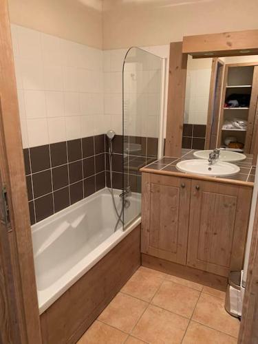 une salle de bain avec une baignoire et un lavabo dans l'établissement Appartement les Coches-Monchavin, à La Plagne Tarentaise