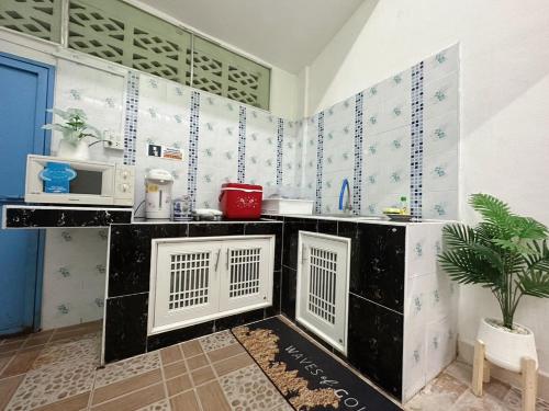 - une cuisine avec des murs carrelés blancs et bleus dans l'établissement Thong Sai Homstay BETONG -ทองใสโฮมสเตย์-, à Betong