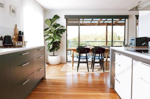 a kitchen with a table and chairs in a room at Omaru Beach House in Scamander