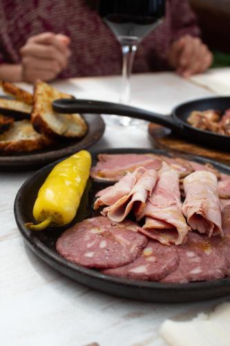 a plate of food with meat and a pickle on a table at Casa Frau Holle in Frutillar