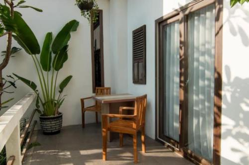 a balcony with a table and chairs and plants at Diva Lombok Resort in Senggigi 