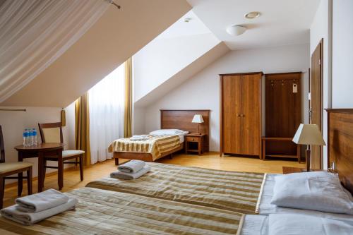 シェミャティチェにあるHotel Kresowiakのベッド2台とテーブルが備わるホテルルームです。