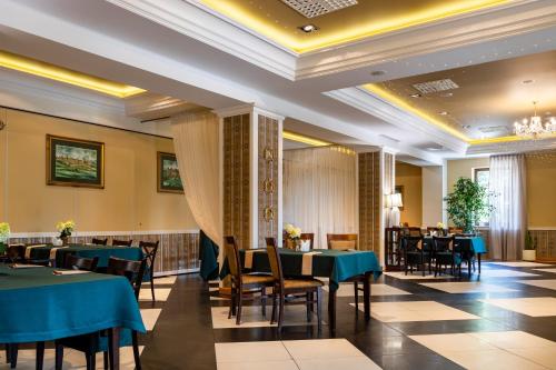 jadalnia z niebieskimi stołami i krzesłami w obiekcie Hotel Kresowiak w mieście Siemiatycze
