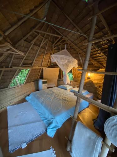 ein Bett in der Mitte eines Zimmers in einer Hütte in der Unterkunft Royal mountain Hut in Ratchaburi
