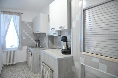 a kitchen with a sink and a counter with a window at casa Venezia in Carovigno