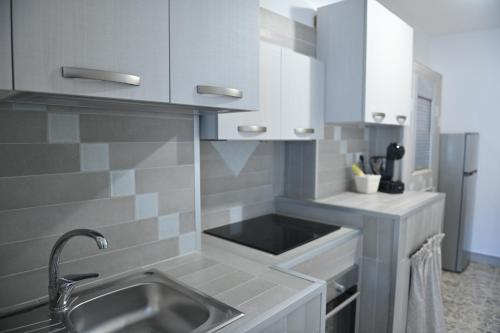 a kitchen with white cabinets and a sink at casa Venezia in Carovigno