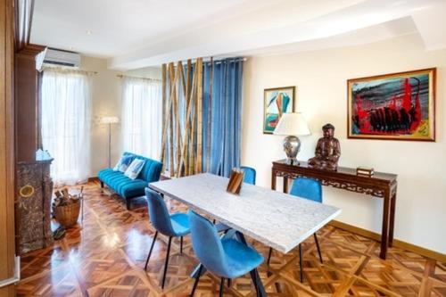 a living room with a table and blue chairs at panoramic luxury penthouse 6 people in Milan