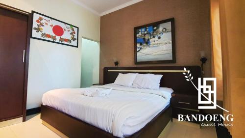 1 dormitorio con 1 cama grande con sábanas blancas en Bandoeng Guest House by Pesen Kamar, en Betek
