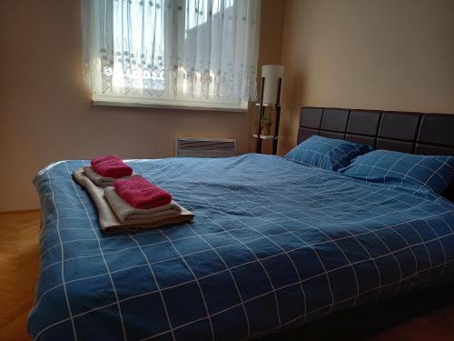 a blue bed with two towels on top of it at Venus Apartman in Brčko