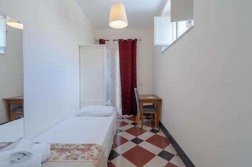 Cette petite chambre comprend deux lits et une table. dans l'établissement Casa De Rollo - Whole House, à Noto