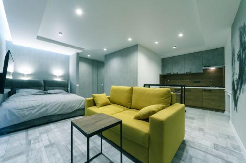 キーウにあるHotrent Olympicのリビングルーム(黄色のソファ、ベッド付)