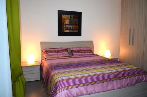 シラクーサにあるTuCasa Ortigia - YouHome Ortigiaのベッドルーム1室(ベッド1台、ナイトスタンド2台、ランプ2つ付)
