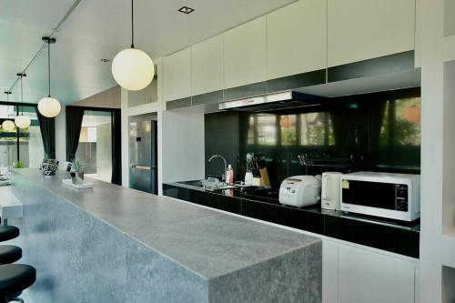 a kitchen with a counter top with a microwave at Futuristic Pool Villa with Stunning Mountain View in Chiang Mai