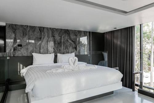 ein Schlafzimmer mit einem weißen Bett mit einer Blume darauf in der Unterkunft Futuristic Pool Villa with Stunning Mountain View in Chiang Mai