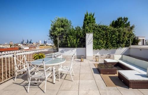 a patio with a table and chairs on a roof at panoramic luxury penthouse 6 people in Milan