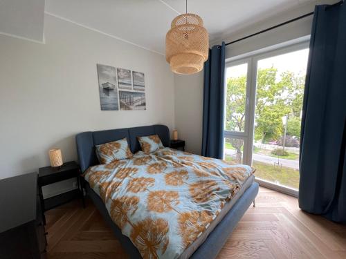 a bedroom with a bed and a large window at Kuuse apartment in Pärnu