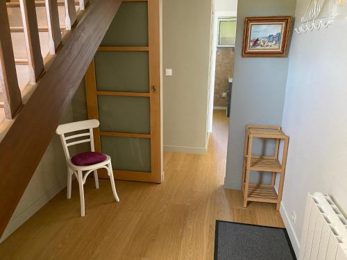 a room with a staircase with a chair and a shelf at maison de vacances ninette in Névez