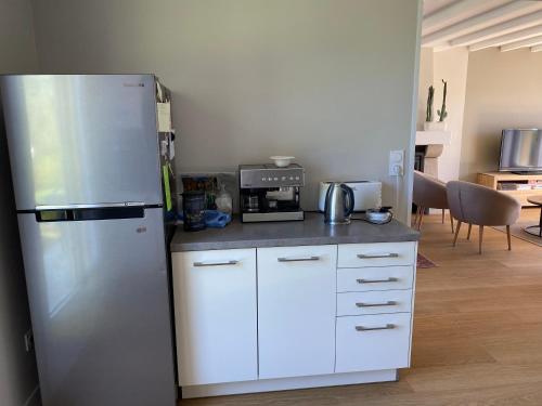 a kitchen with a stainless steel refrigerator and a microwave at maison de vacances ninette in Névez