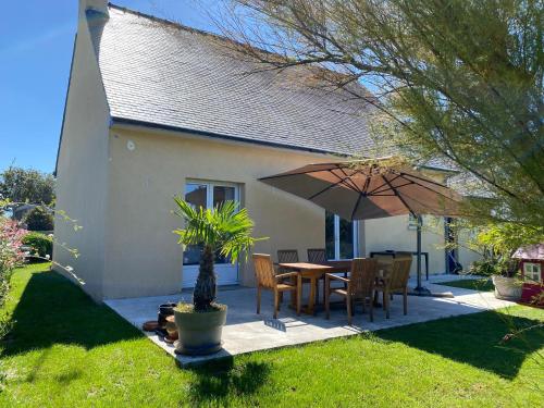 a patio with a table and an umbrella at maison de vacances ninette in Névez
