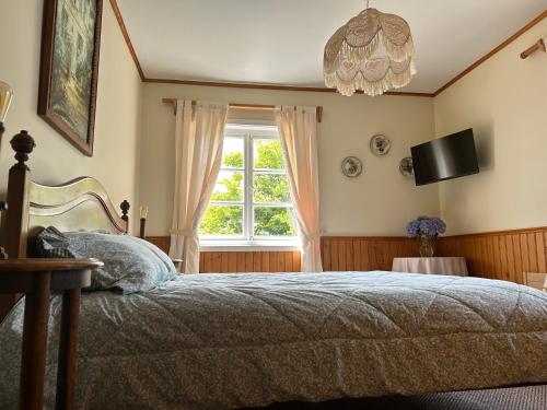 a bedroom with a bed and a window and a chandelier at Casa Frau Holle in Frutillar