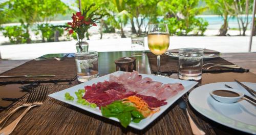 a table with a plate of food and a glass of wine at Navutu Stars Resort in Matayalevu