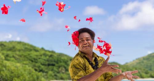 a man with flowers on his head and butterflies at Navutu Stars Resort in Matayalevu