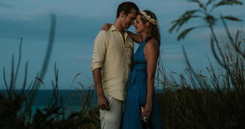 a man and a woman standing next to the ocean at Navutu Stars Resort in Matayalevu