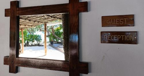 a mirror hanging on a wall with a guest rejection sign at Navutu Stars Resort in Matayalevu