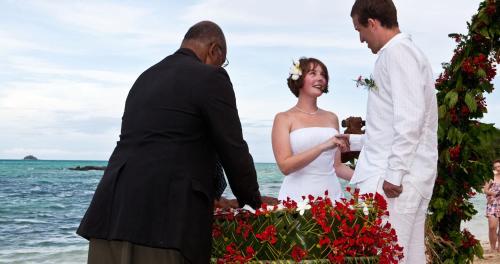 a bride and groom at their wedding on the beach at Navutu Stars Resort in Matayalevu
