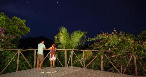 a man and a girl standing on a bridge at night at Navutu Stars Resort in Matayalevu