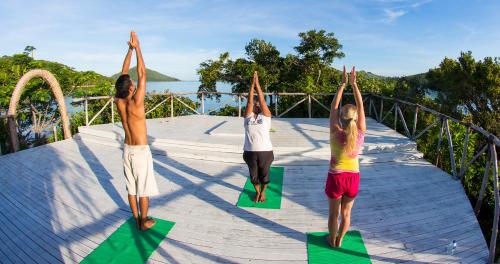 three people doing a yoga pose on a bridge at Navutu Stars Resort in Matayalevu